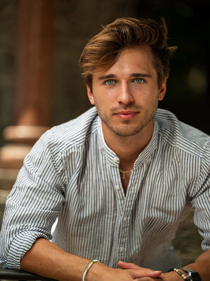 Professional young man in striped shirt sitting at table with confident smile and styled hair - Dysport in Owings Mills, MD