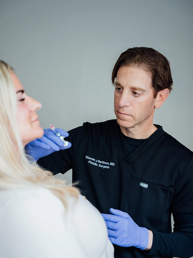 Dr Rottman MD examining patient's face for cosmetic treatment consultation - Lip injections in Owings Mills, MD