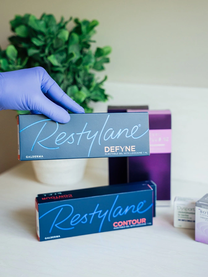 Restylane dermal filler products Refyne and Contour displayed by gloved hand in medical office setting - Restylane in Owings Mills, MD